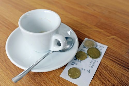 © photophonie - stock.adobe.com Foto: Kaffeetasse mit Rechnung und Münzen